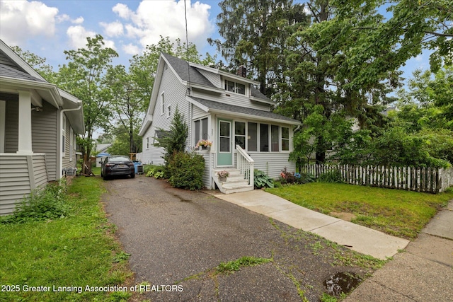 527 N Hayford Ave, Lansing, MI 48912 - view of front of home featuring entry steps, a shingled roof, asphalt driveway, and a sunroom