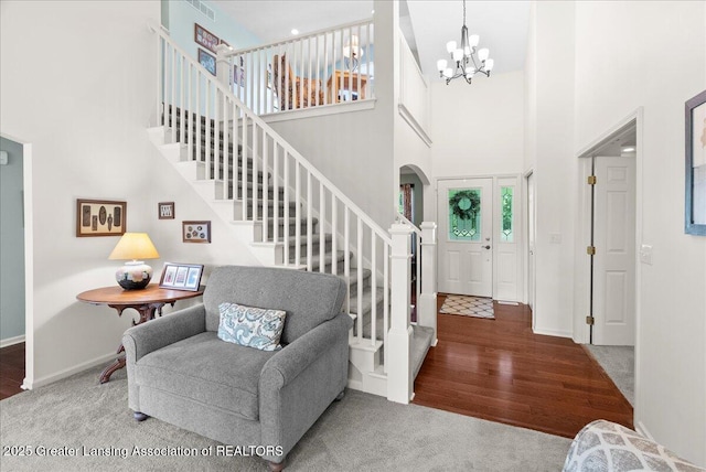 2134 Cedar Bend Dr, Holt, MI 48842 - carpeted entryway featuring a towering ceiling, arched walkways, a chandelier, stairway, and wood finished floors