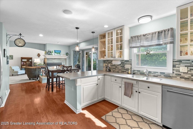 2134 Cedar Bend Dr, Holt, MI 48842 - kitchen featuring stainless steel dishwasher, a peninsula, dark wood finished floors, backsplash, and white cabinets