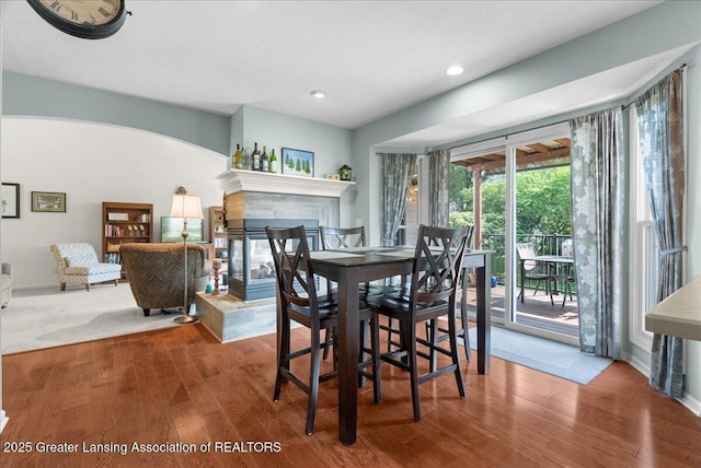 2134 Cedar Bend Dr, Holt, MI 48842 - dining area with arched walkways, recessed lighting, wood finished floors, and a tiled fireplace