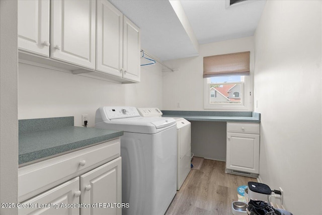 2134 Cedar Bend Dr, Holt, MI 48842 - laundry room featuring washing machine and dryer, light wood-type flooring, and cabinet space