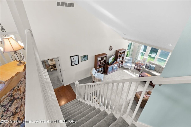 2134 Cedar Bend Dr, Holt, MI 48842 - stairway featuring high vaulted ceiling and carpet