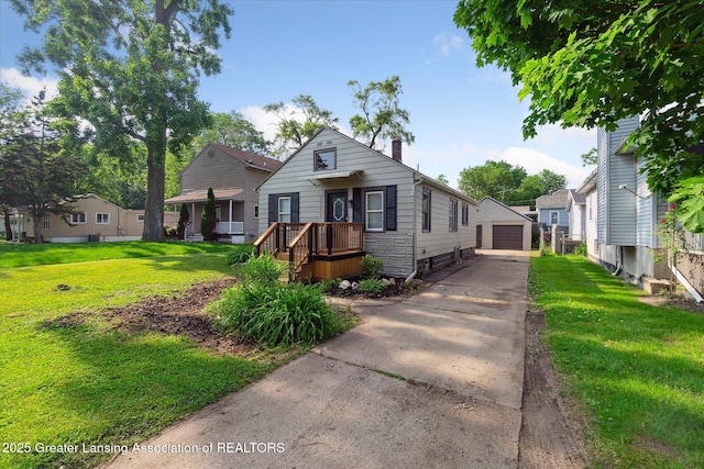 2506 W Kalamazoo St, Lansing, MI 48917 - view of front of house featuring a front lawn, a detached garage, a chimney, and an outbuilding