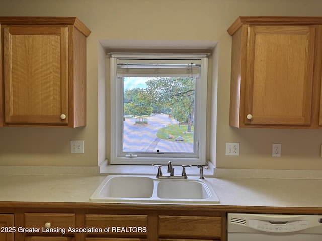 411 White Pine Blvd Unit 34, Lansing, MI 48917 - kitchen featuring dishwasher, light countertops, and brown cabinetry