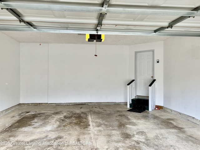 411 White Pine Blvd Unit 34, Lansing, MI 48917 - garage featuring a garage door opener and baseboards