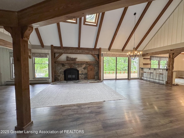 12855 Oneida Woods Trl, Grand Ledge, MI 48837 - unfurnished living room with high vaulted ceiling, a chandelier, beamed ceiling, a fireplace, and wood finished floors