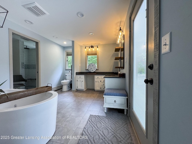 12855 Oneida Woods Trl, Grand Ledge, MI 48837 - bathroom with a freestanding tub, toilet, vanity, baseboard heating, and recessed lighting