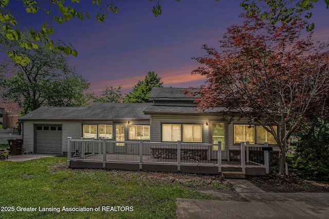 131 W S St, Williamston, MI 48895 - view of front facade with an attached garage, a yard, and a shingled roof