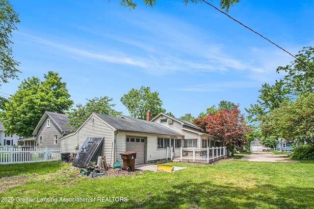 131 W S St, Williamston, MI 48895 - back of house with an attached garage and a chimney