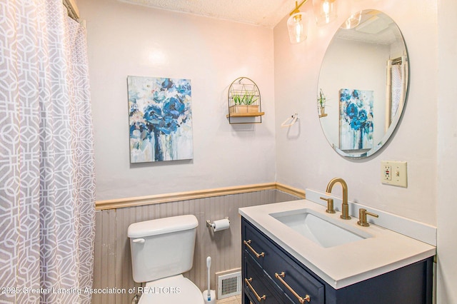 131 W S St, Williamston, MI 48895 - bathroom with a wainscoted wall, vanity, toilet, and a textured ceiling