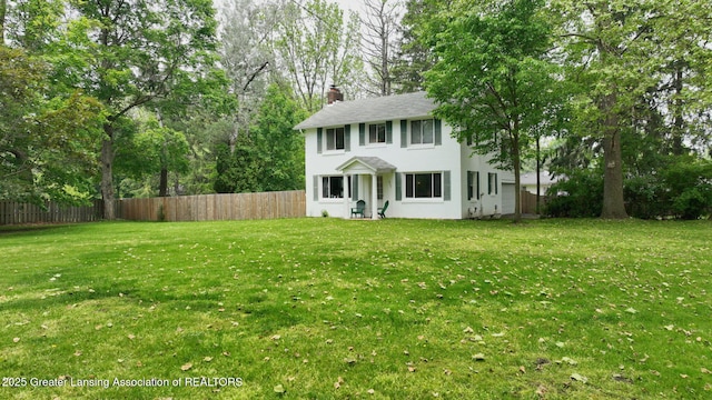 627 State St, Eaton Rapids, MI 48827 - colonial house with stucco siding, a chimney, roof with shingles, and view of wooded area