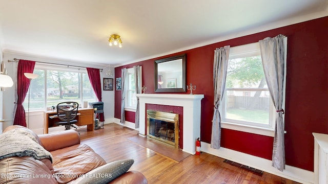 627 State St, Eaton Rapids, MI 48827 - living area with a glass covered fireplace, wood finished floors, baseboards, and a desk