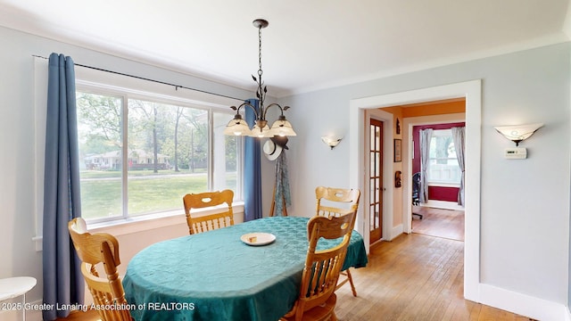 627 State St, Eaton Rapids, MI 48827 - dining area with baseboards, light wood-type flooring, and a chandelier
