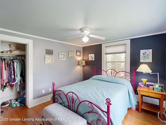 627 State St, Eaton Rapids, MI 48827 - bedroom with a closet, wood finished floors, crown molding, a ceiling fan, and baseboards