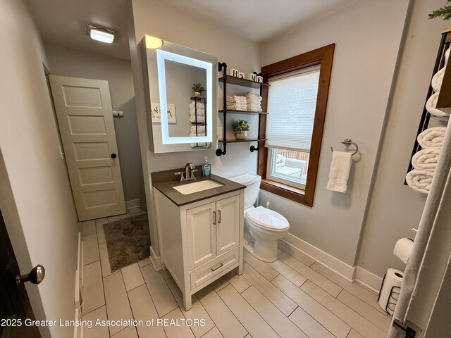 227 S Foster Ave, Lansing, MI 48912 - bathroom with vanity, toilet, tile patterned floors, and baseboards