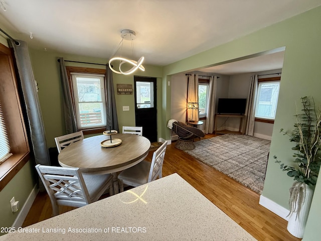 227 S Foster Ave, Lansing, MI 48912 - dining area with wood finished floors, baseboards, and a chandelier