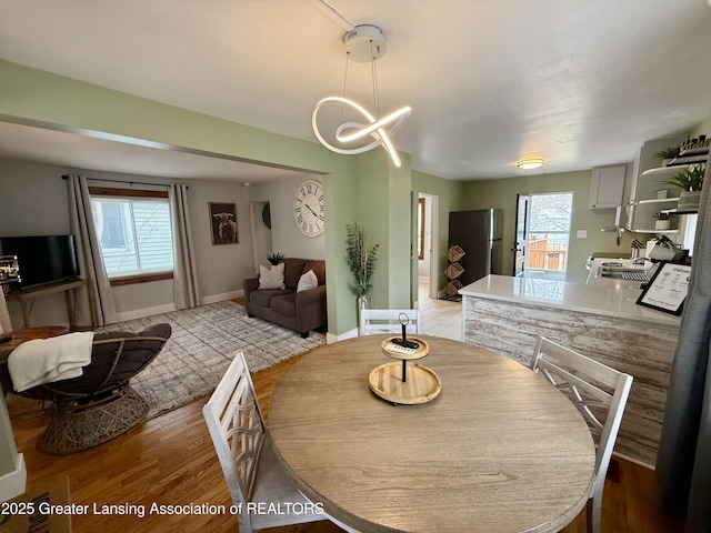 227 S Foster Ave, Lansing, MI 48912 - dining area with light wood-type flooring, a chandelier, and baseboards