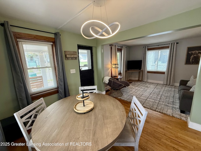 227 S Foster Ave, Lansing, MI 48912 - dining space featuring wood finished floors, a chandelier, and baseboards