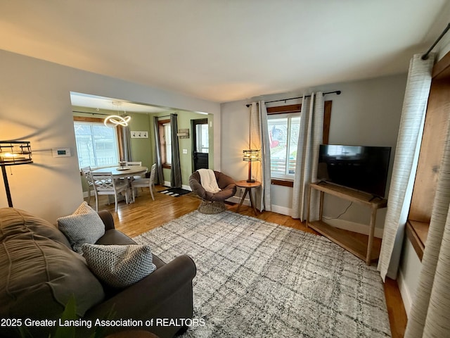 227 S Foster Ave, Lansing, MI 48912 - living room with plenty of natural light, wood finished floors, baseboards, and a chandelier