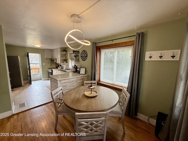 227 S Foster Ave, Lansing, MI 48912 - dining area featuring baseboards and light wood-type flooring