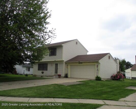 4818 Moultrie Cir, Lansing, MI 48917 - colonial home featuring an attached garage, concrete driveway, and a front lawn