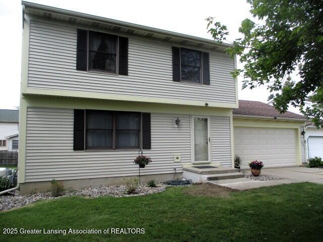 4818 Moultrie Cir, Lansing, MI 48917 - colonial inspired home with an attached garage, driveway, and a front lawn