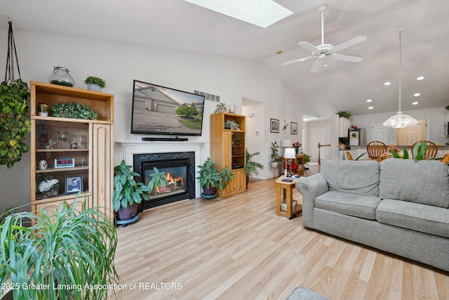 1703 Willow Creek Dr Unit 29, Lansing, MI 48917 - living room with light wood finished floors, a fireplace, a skylight, a ceiling fan, and recessed lighting