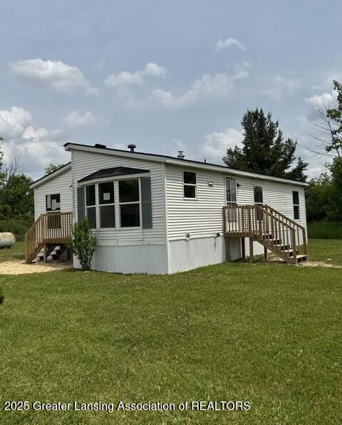 26506 E Baseline Hwy, Charlotte, MI 48813 - rear view of house featuring a lawn and stairs