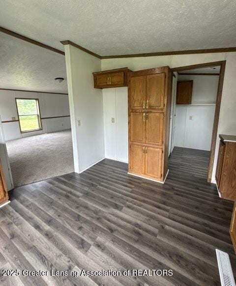 26506 E Baseline Hwy, Charlotte, MI 48813 - unfurnished bedroom with a textured ceiling, dark wood finished floors, and crown molding