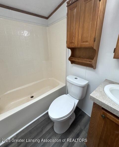 26506 E Baseline Hwy, Charlotte, MI 48813 - full bath with wood finished floors, toilet, vanity, ornamental molding, and bathing tub / shower combination