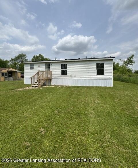 26506 E Baseline Hwy, Charlotte, MI 48813 - rear view of house featuring a lawn
