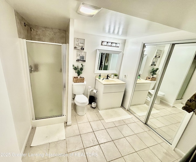 3130 Delta River Dr, Lansing, MI 48906 - bathroom featuring toilet, a shower stall, vanity, and tile patterned floors