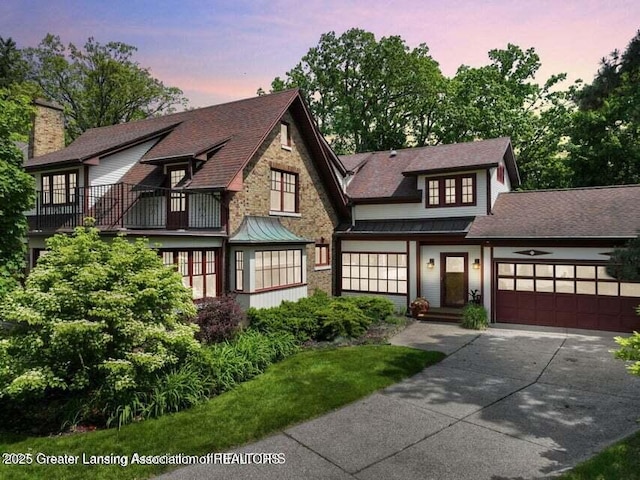 1046 Cresenwood Rd, East Lansing, MI 48823 - view of front of home featuring concrete driveway, a standing seam roof, a balcony, an attached garage, and a metal roof