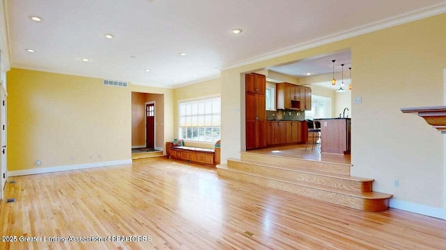 1046 Cresenwood Rd, East Lansing, MI 48823 - unfurnished living room featuring light wood-style flooring, ornamental molding, and recessed lighting