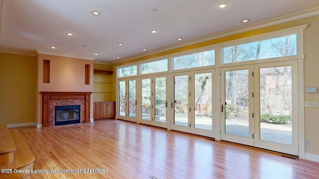 1046 Cresenwood Rd, East Lansing, MI 48823 - unfurnished living room featuring ornamental molding, light wood-style flooring, a tile fireplace, and recessed lighting