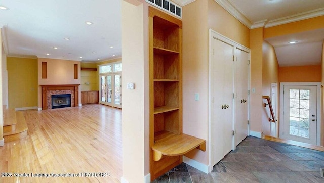 1046 Cresenwood Rd, East Lansing, MI 48823 - mudroom featuring a glass covered fireplace, built in shelves, ornamental molding, recessed lighting, and wood finished floors