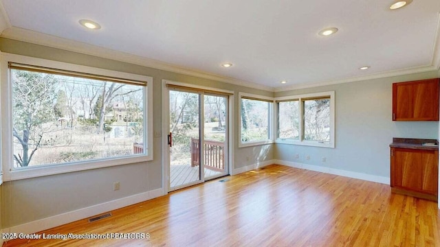 1046 Cresenwood Rd, East Lansing, MI 48823 - unfurnished dining area featuring healthy amount of natural light, crown molding, light wood-style flooring, and recessed lighting