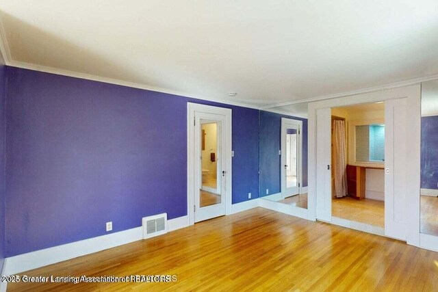 1046 Cresenwood Rd, East Lansing, MI 48823 - empty room with wood finished floors and crown molding