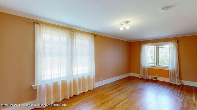 1046 Cresenwood Rd, East Lansing, MI 48823 - spare room featuring a smoke detector, ornamental molding, and wood finished floors