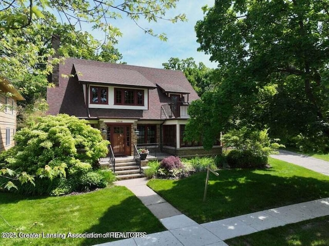 1046 Cresenwood Rd, East Lansing, MI 48823 - view of front of property with a balcony, a front yard, and stone siding