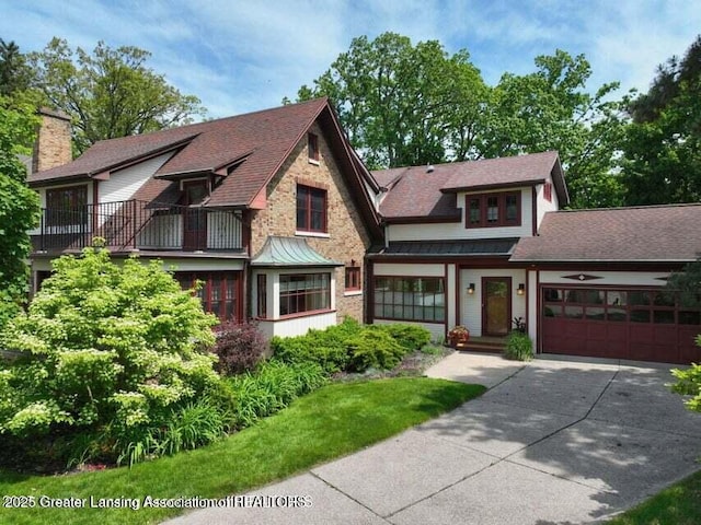 1046 Cresenwood Rd, East Lansing, MI 48823 - view of front of home with concrete driveway, a standing seam roof, an attached garage, a shingled roof, and a balcony
