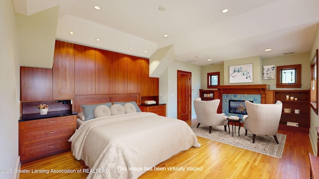1046 Cresenwood Rd, East Lansing, MI 48823 - bedroom featuring light wood-style floors, a glass covered fireplace, recessed lighting, and a closet