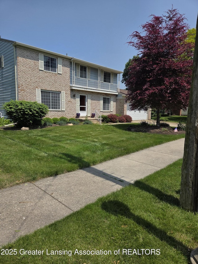 2115 Lyman Dr, Lansing, MI 48912 - view of front of property featuring brick siding, a balcony, and a front yard