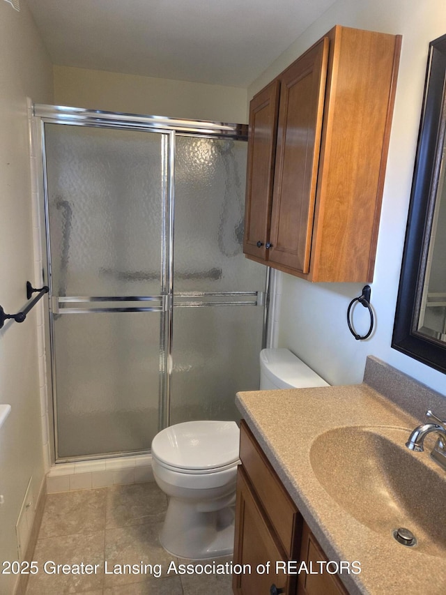 2115 Lyman Dr, Lansing, MI 48912 - full bathroom with vanity, toilet, a stall shower, and tile patterned floors