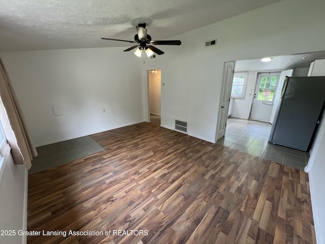 4219 Richmond St, Lansing, MI 48911 - unfurnished living room with wood finished floors, a ceiling fan, a textured ceiling, and baseboards