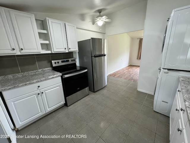 4219 Richmond St, Lansing, MI 48911 - kitchen featuring stainless steel appliances, ceiling fan, stacked washer and clothes dryer, vaulted ceiling, and white cabinets