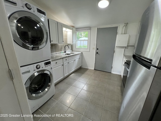 4219 Richmond St, Lansing, MI 48911 - washroom with stacked washing machine and dryer, light tile patterned floors, and baseboards