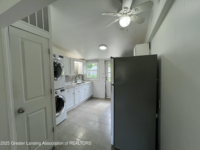 4219 Richmond St, Lansing, MI 48911 - washroom featuring estacked washer and dryer, ceiling fan, light tile patterned floors, and a sink