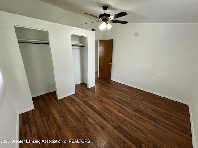 4219 Richmond St, Lansing, MI 48911 - unfurnished bedroom featuring two closets, dark wood-type flooring, baseboards, and a ceiling fan