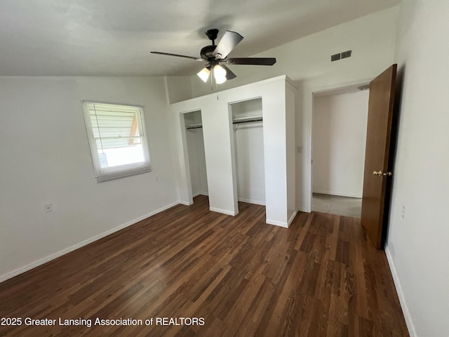 4219 Richmond St, Lansing, MI 48911 - unfurnished bedroom featuring two closets, dark wood-style floors, baseboards, and ceiling fan